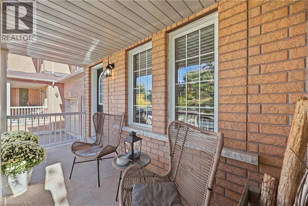 Covered front porch with brick exterior, white railing, and white window trim - 2409 Postmaster Drive, Oakville, ON