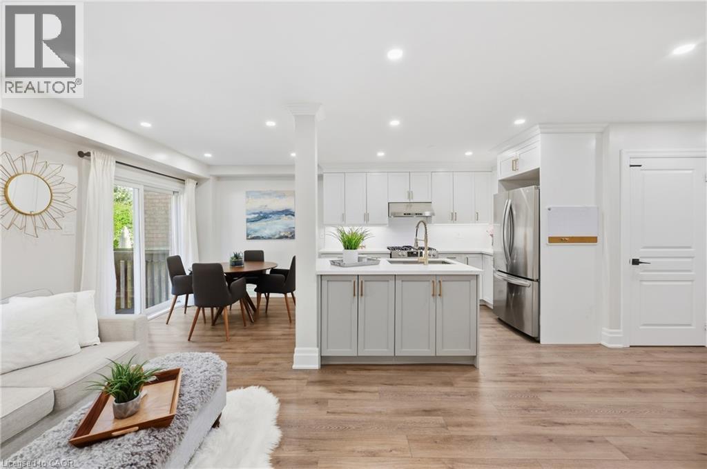 Open-concept living space with wood-finish flooring, recessed lighting, and a sliding glass door - 2409 Postmaster Drive, Oakville, ON