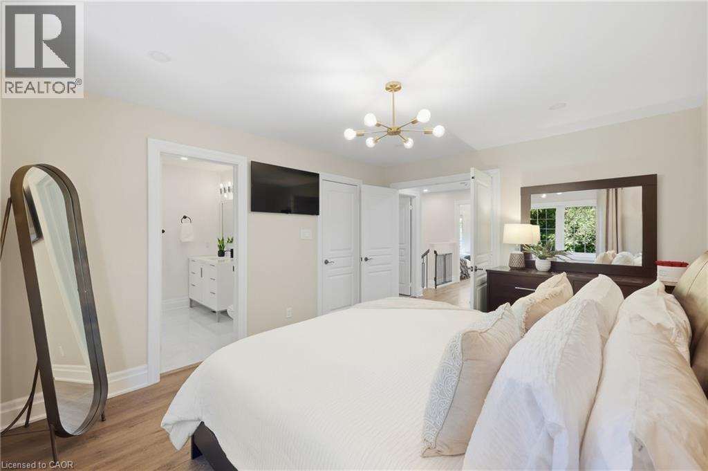 Wood-finish flooring, contemporary chandelier, recessed lighting, white trim, and a white vanity with vessel sink - 2409 Postmaster Drive, Oakville, ON