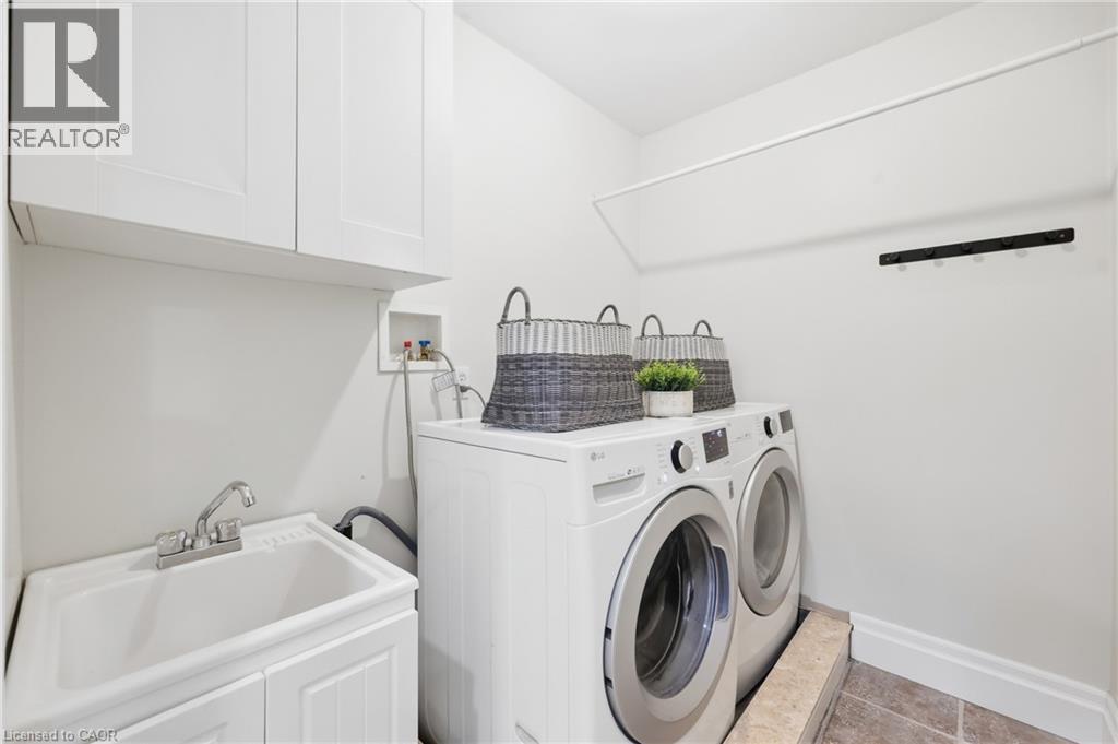 White upper cabinetry, utility sink with base cabinet, and an integrated drying rod - 2409 Postmaster Drive, Oakville, ON