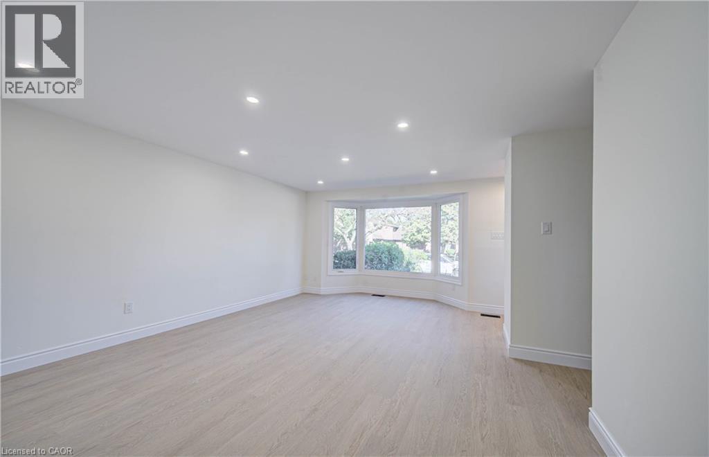 Recessed lighting, wood-finish flooring, bay window, white walls, and white trim - 210 Ferguson Avenue, Cambridge, ON