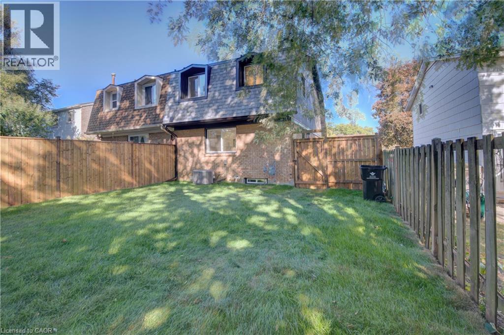 Expansive grassy yard with wood fencing and a gate - 210 Ferguson Avenue, Cambridge, ON