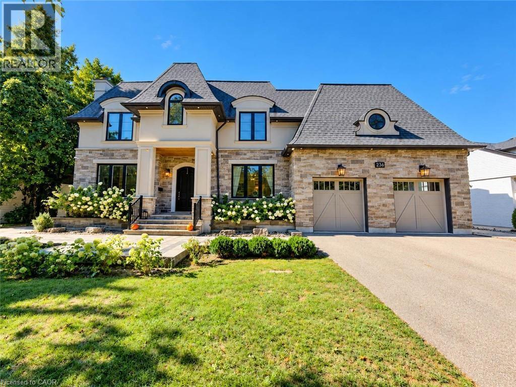 Stone and stucco facade featuring a prominent portico and multiple dormer windows - 236 Poplar Drive, Burlington, ON