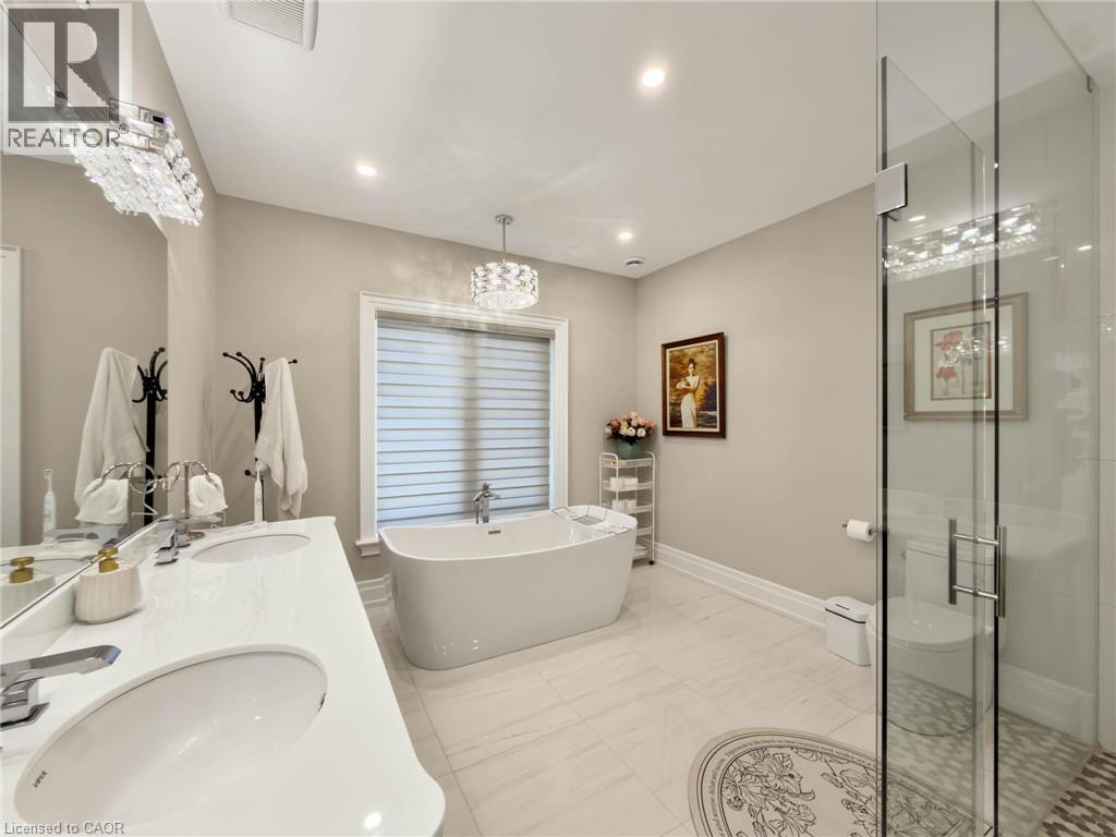 Freestanding soaking tub, dual vanity with undermount sinks, frameless glass shower enclosure, and recessed lighting - 236 Poplar Drive, Burlington, ON