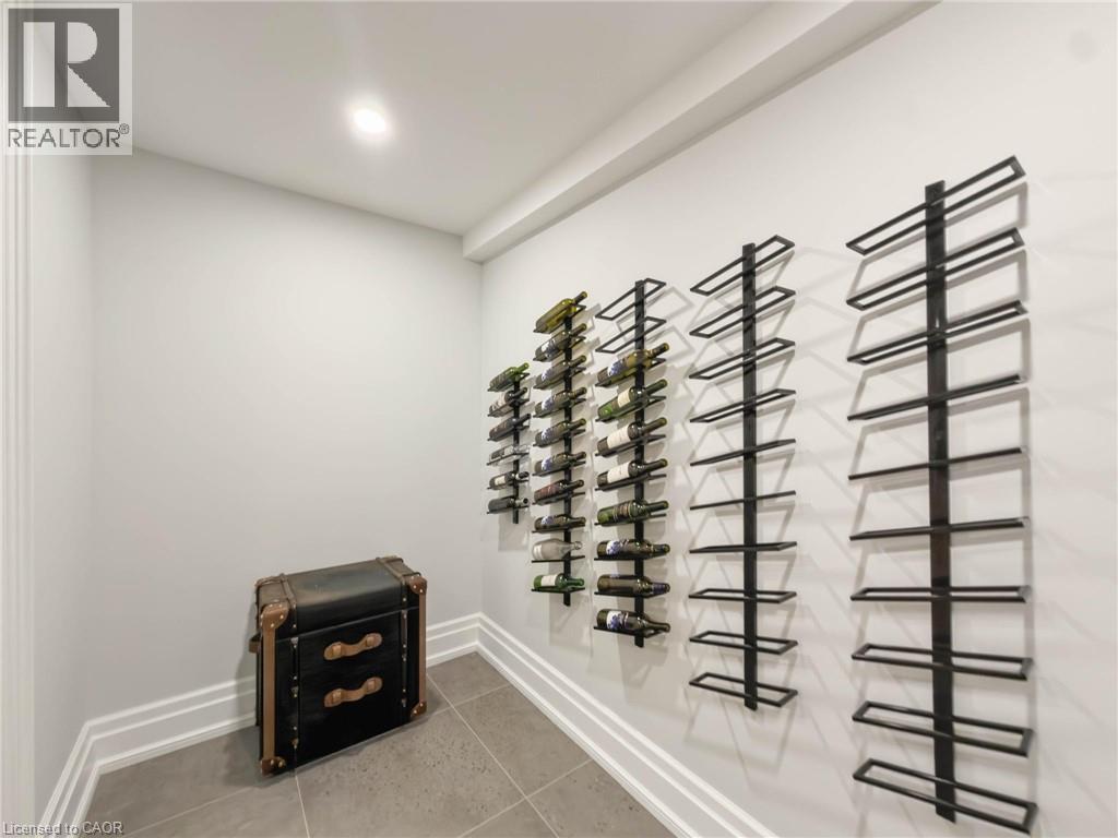 Recessed ceiling lighting, wall-mounted wine storage racks, tile flooring, and layered base molding - 236 Poplar Drive, Burlington, ON