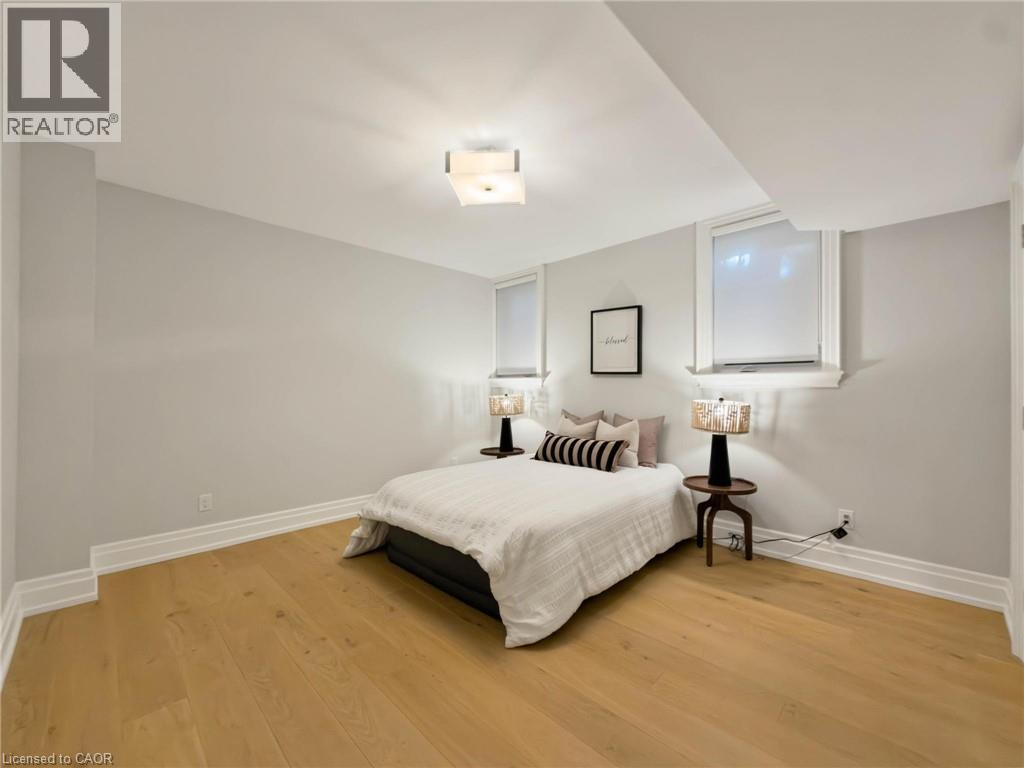 Light wood-finish flooring, two windows with blinds, recessed ceiling, and a flush mount light fixture - 236 Poplar Drive, Burlington, ON