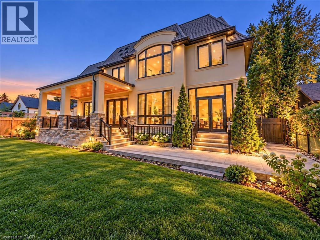 Stucco exterior with extensive window placements and a covered patio - 236 Poplar Drive, Burlington, ON