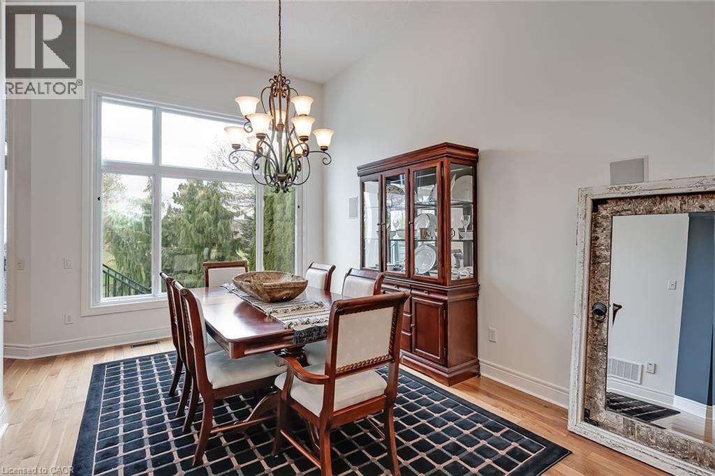 Soaring ceiling height, wood-finish flooring, large multi-pane window, decorative chandelier, and built-in display cabinetry - 4285 Couples Crescent, Burlington, ON