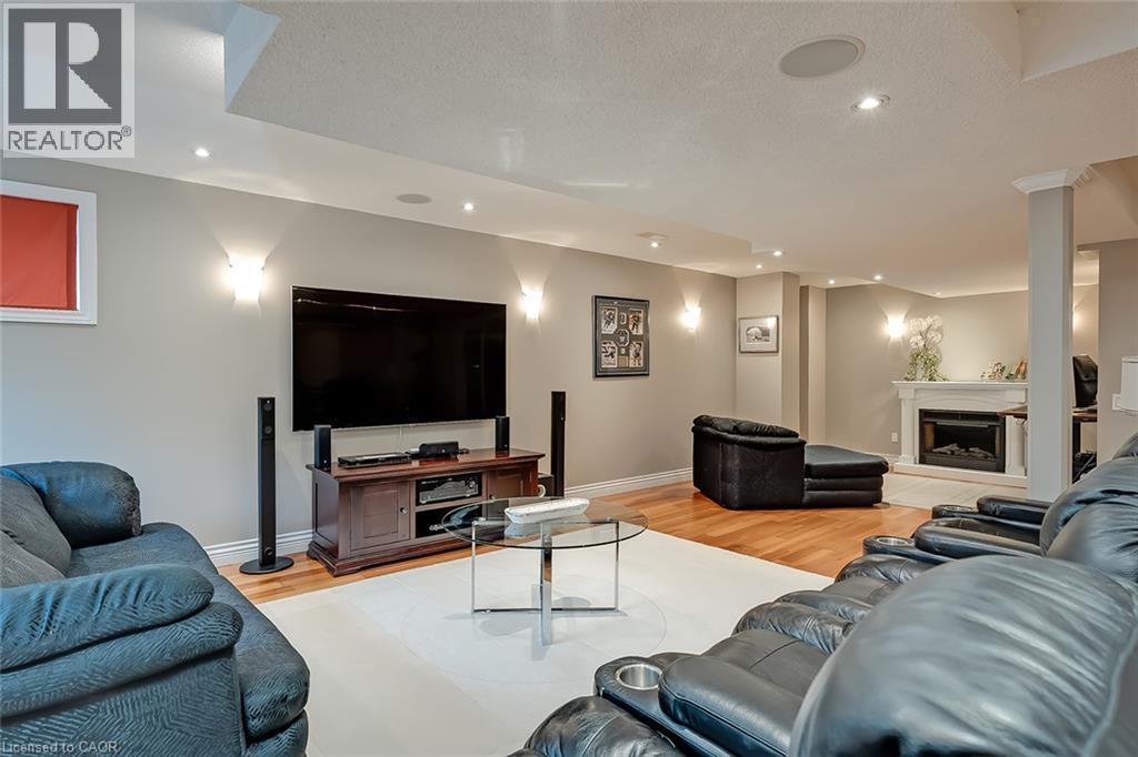 Hardwood flooring, recessed lighting, built-in ceiling speakers, wall-mounted sconces, and a gas fireplace with a mantel - 4285 Couples Crescent, Burlington, ON