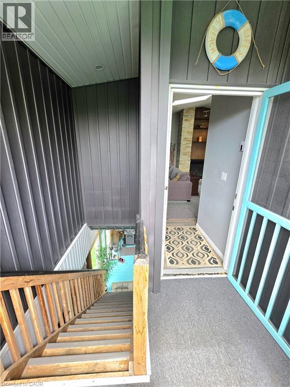 Front entry with gray carpet flooring and a light blue screen door - 16 Forest Hill Road, St. Catharines, ON