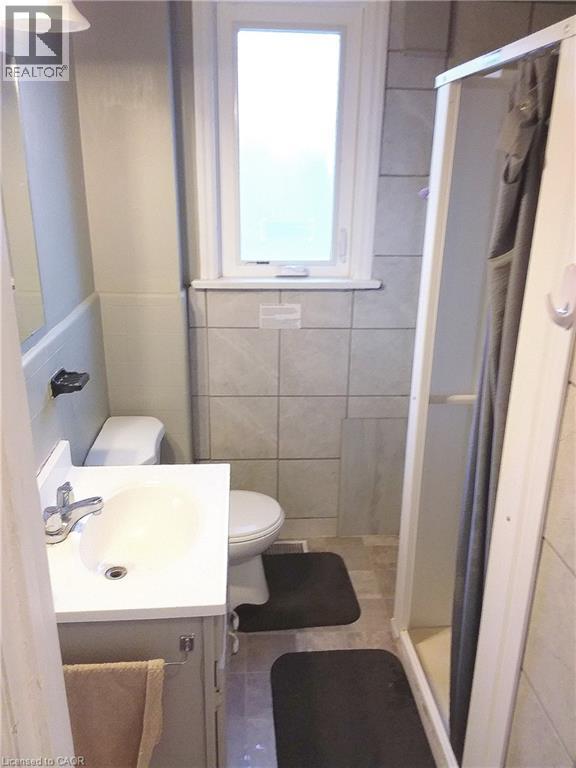 Main floor bathroom featuring a vanity with a white countertop and a stand-up shower - 16 Forest Hill Road, St. Catharines, ON