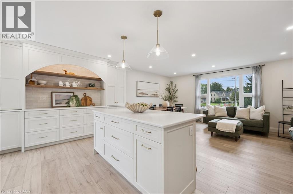 Open-concept layout featuring wood-finish flooring, recessed lighting, and a kitchen island with a light-toned countertop - 8 Christian Street, Baden, ON