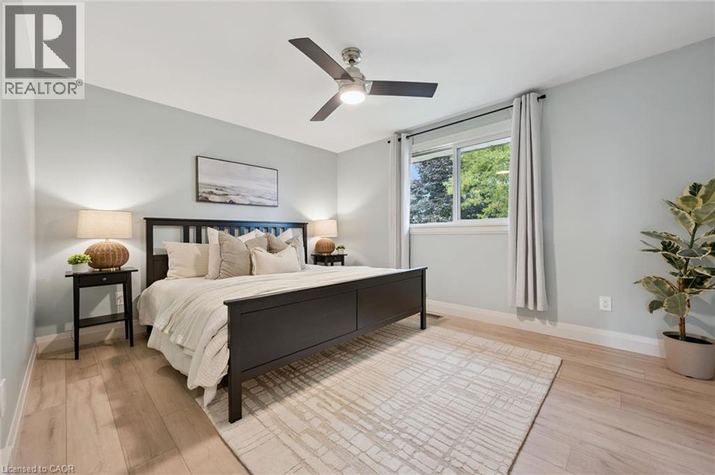 Light wood-finish flooring, a ceiling fan with integrated lighting, and a white-framed window - 8 Christian Street, Baden, ON