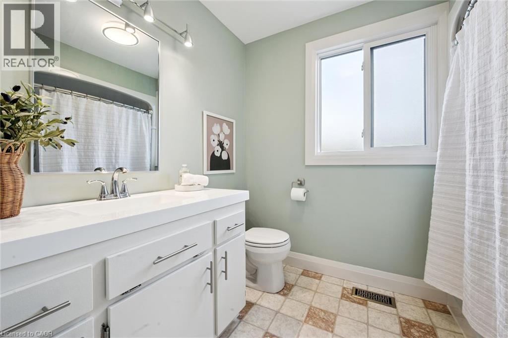 White vanity with chrome hardware, an integrated sink, and a framed mirror - 8 Christian Street, Baden, ON