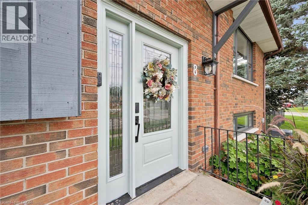 Brick exterior with a light-colored entry door and sidelight - 8 Christian Street, Baden, ON