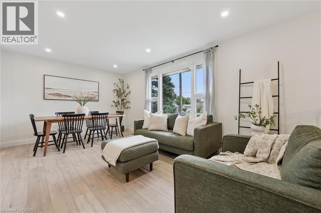 Recessed lighting, wood-finish flooring, white walls, large window with drapes, and a dining area with a wooden table - 8 Christian Street, Baden, ON