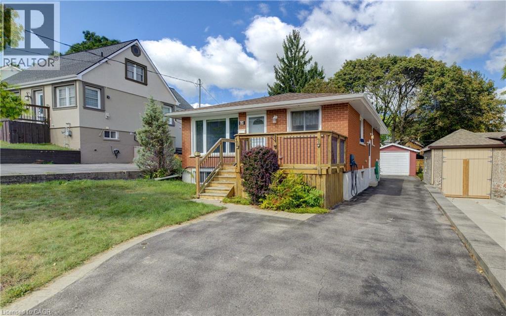 Brick exterior with a front deck and wooden railing - 64 Stanley Street, Cambridge, ON