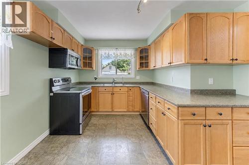 U-shaped kitchen featuring wood-finish cabinetry, a stainless steel range, and a built-in microwave - 64 Stanley Street, Cambridge, ON 