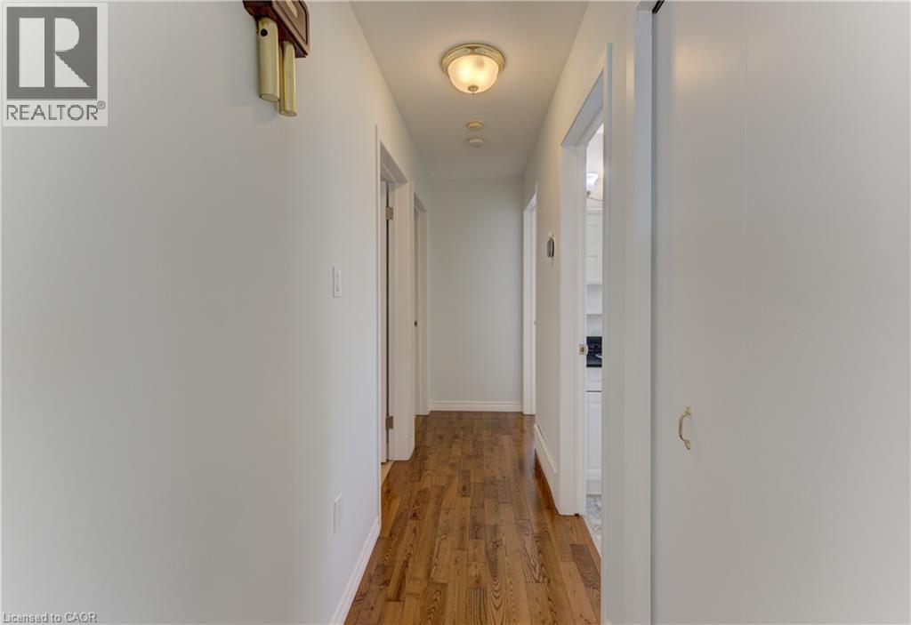 Hallway featuring wood-finish flooring, white walls, and a flush-mount ceiling light - 64 Stanley Street, Cambridge, ON