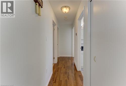 Hallway featuring wood-finish flooring, white walls, and a flush-mount ceiling light - 64 Stanley Street, Cambridge, ON 