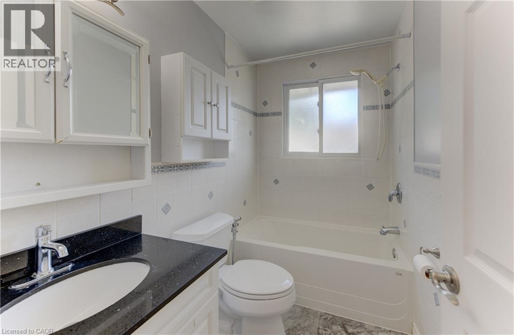 Integrated vanity with black speckled countertop and undermount sink - 64 Stanley Street, Cambridge, ON