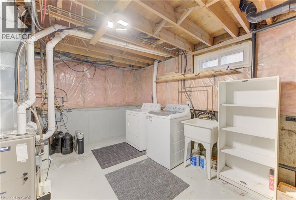 Utility area with exposed ceiling joists, a utility sink, and a high-level window - 64 Stanley Street, Cambridge, ON