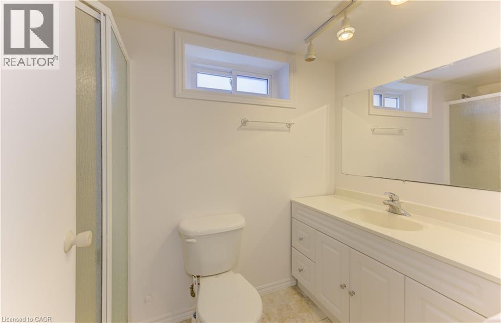 White vanity with integrated sink, chrome faucet, and mirrored wall - 64 Stanley Street, Cambridge, ON