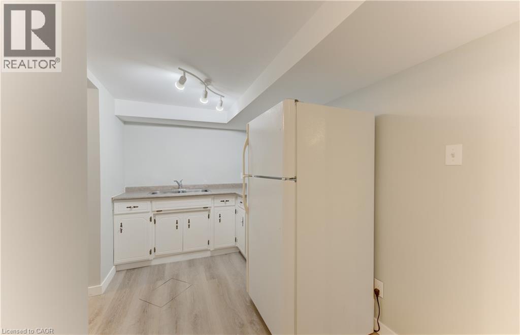 White cabinetry with dark hardware and a built-in sink - 64 Stanley Street, Cambridge, ON