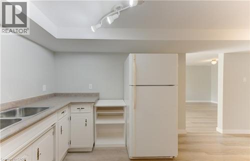 Kitchenette featuring white cabinetry, a double basin stainless steel sink, and track lighting - 64 Stanley Street, Cambridge, ON 