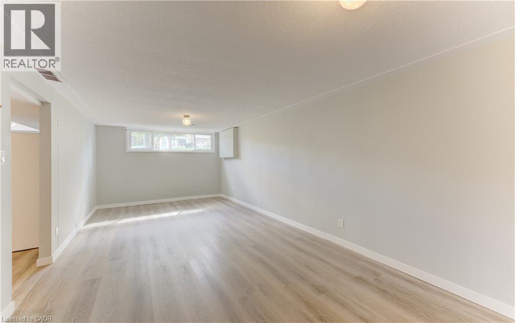 Recessed windows, light wood-finish flooring, and a flush mount light fixture - 64 Stanley Street, Cambridge, ON