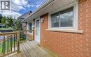 Brick exterior with a wood deck, white window trim, and exterior wall lighting - 64 Stanley Street, Cambridge, ON 