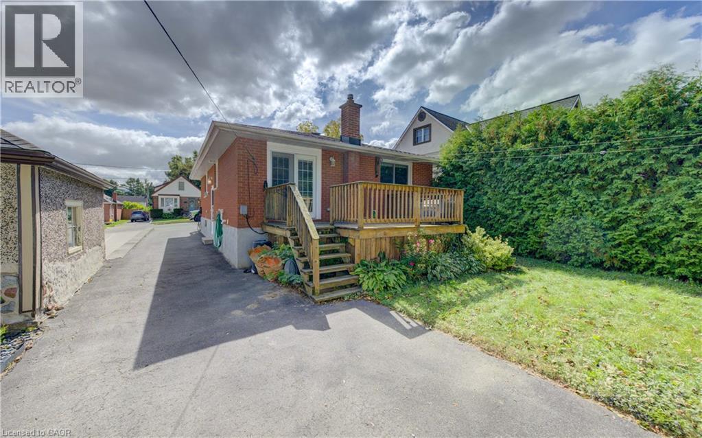 Rear brick exterior with a wood deck featuring a railing and steps - 64 Stanley Street, Cambridge, ON