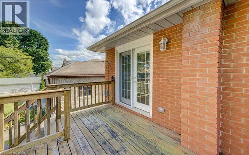 Exterior brick wall with an attached deck featuring wood railing and wood-finish flooring - 64 Stanley Street, Cambridge, ON 