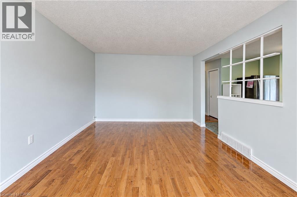 Wood-finish flooring with light blue wall paint, white baseboards, and a decorative interior window - 64 Stanley Street, Cambridge, ON
