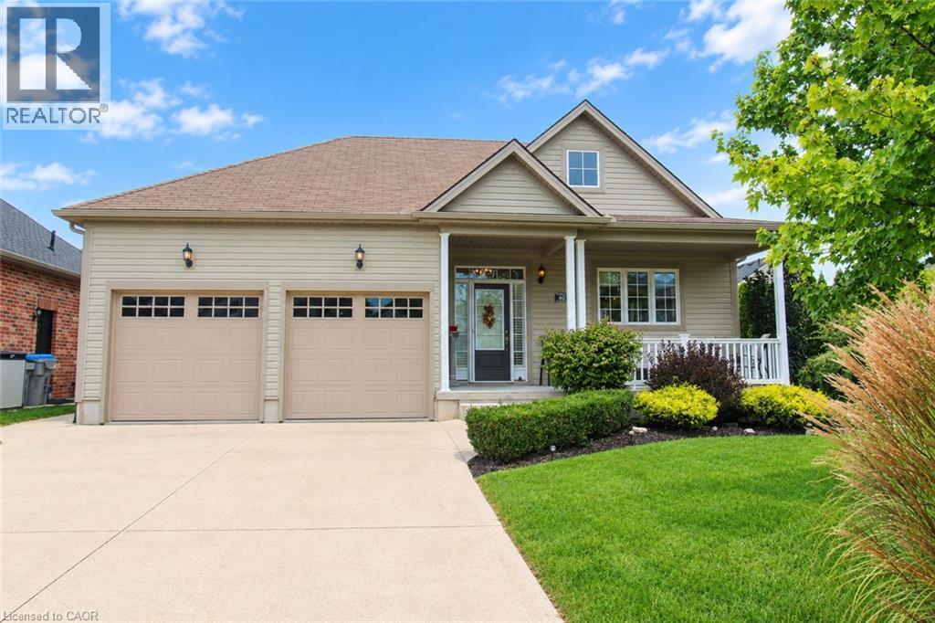 Pitched roof dwelling with beige siding and two-car garage - 40 Stornoway Crescent, Huron East, ON