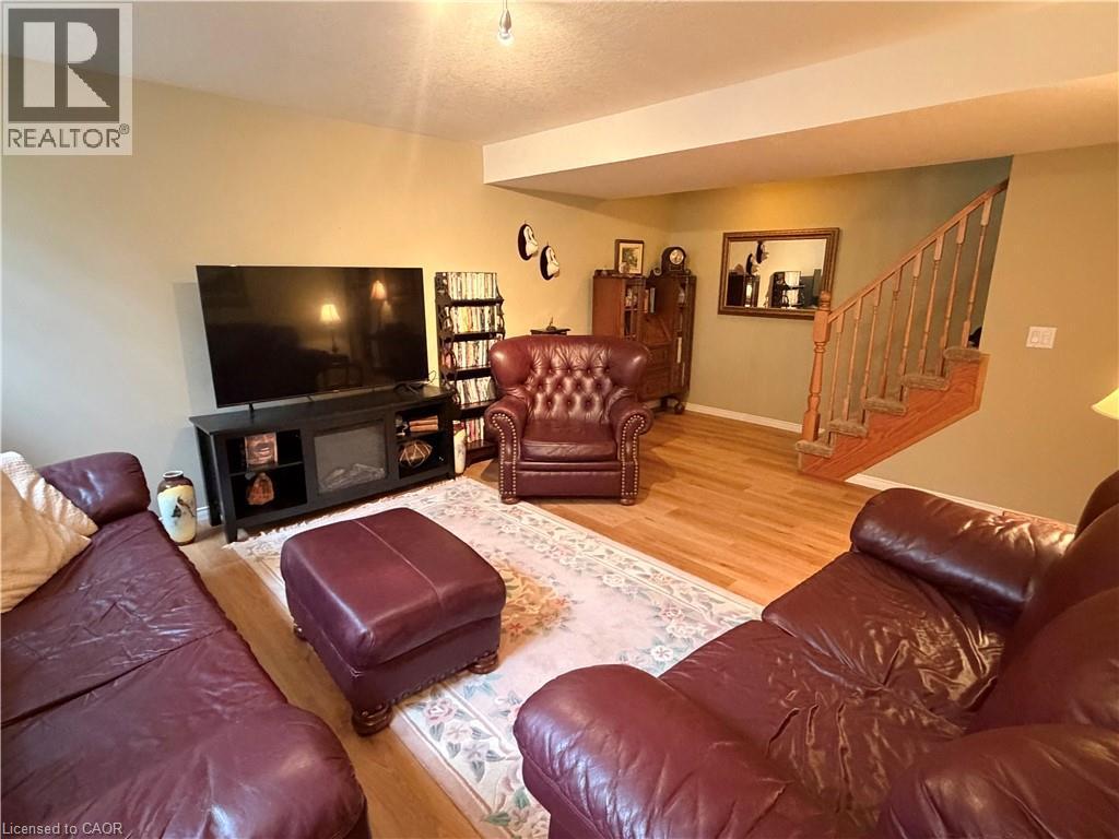 Wood-finish flooring throughout, complemented by a built-in entertainment console with an integrated electric fireplace - 40 Stornoway Crescent, Huron East, ON