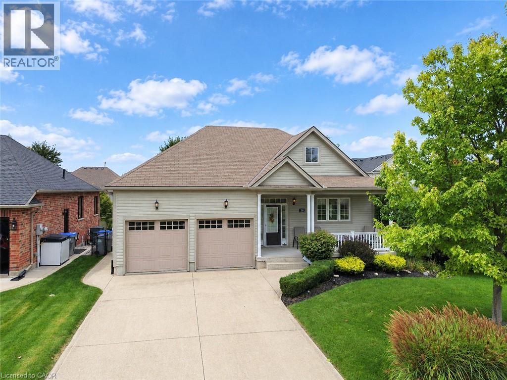 Two-car attached garage, covered front porch, concrete driveway, front yard landscaping, and exterior siding - 40 Stornoway Crescent, Huron East, ON