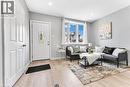 Light wood-finish flooring, recessed lighting, bay window, and a white front entry door with decorative glass inlay - 101 Emerald Street N, Hamilton, ON 