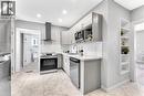 Kitchen featuring stainless steel appliances, upper and lower cabinetry, an undermount sink, and a tiled backsplash - 101 Emerald Street N, Hamilton, ON 