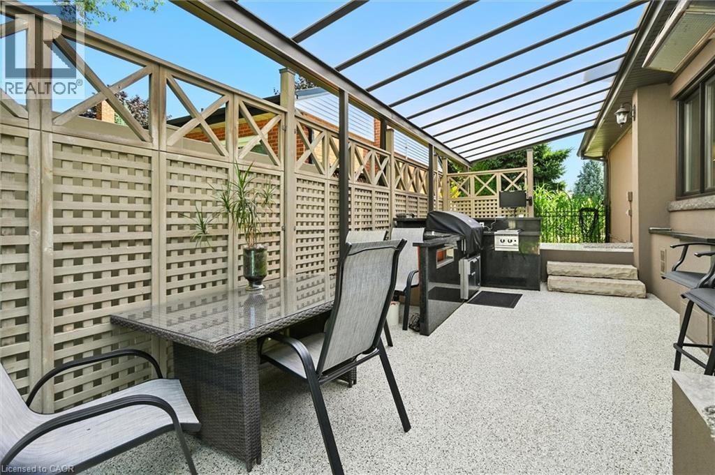 Covered patio featuring a translucent roof, full outdoor kitchen, and stone steps - 2209 Ghent Avenue, Burlington, ON