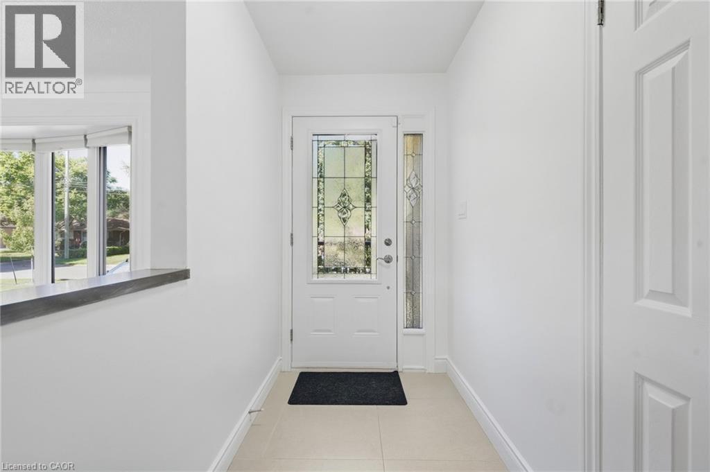 Entryway featuring a decorative glass door, coordinating sidelight, and tile flooring - 49 Beverly Crescent, Welland, ON