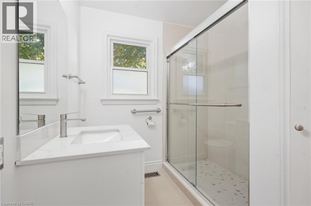 White vanity with integrated sink, modern brushed nickel faucet, and white countertop - 49 Beverly Crescent, Welland, ON