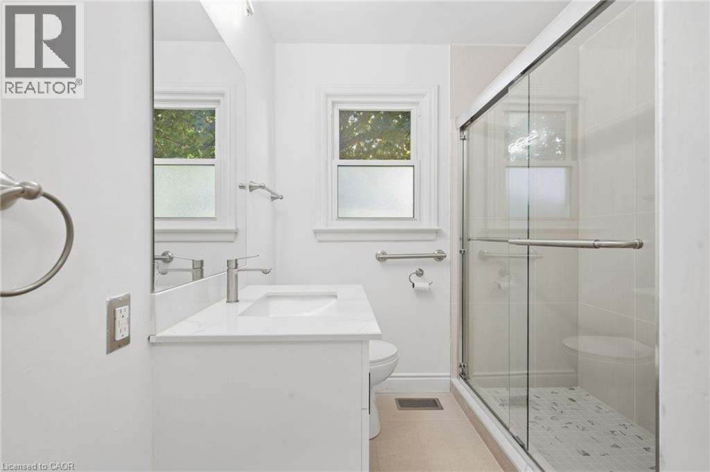 White vanity with an integrated sink, polished chrome faucet, and quartz countertop - 49 Beverly Crescent, Welland, ON