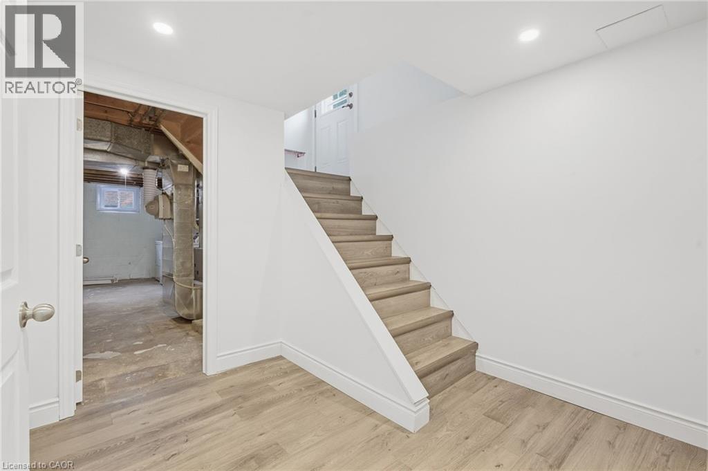 Wood-finish flooring, white painted walls, and recessed lighting - 49 Beverly Crescent, Welland, ON