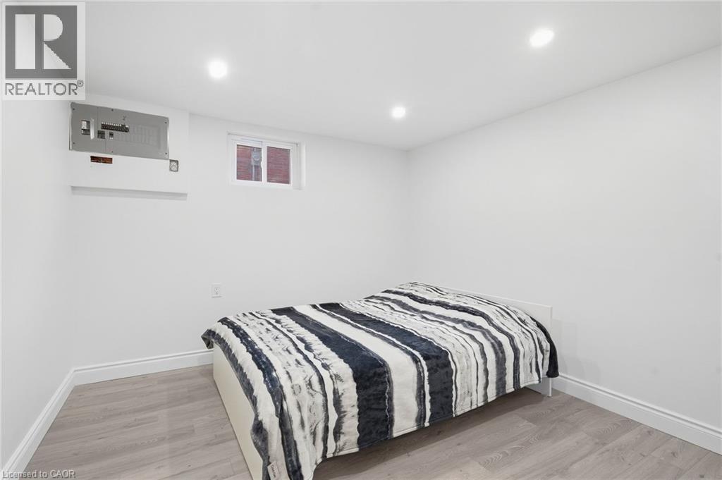 Recessed ceiling lighting, light wood-finish flooring, white painted walls, and a window - 49 Beverly Crescent, Welland, ON