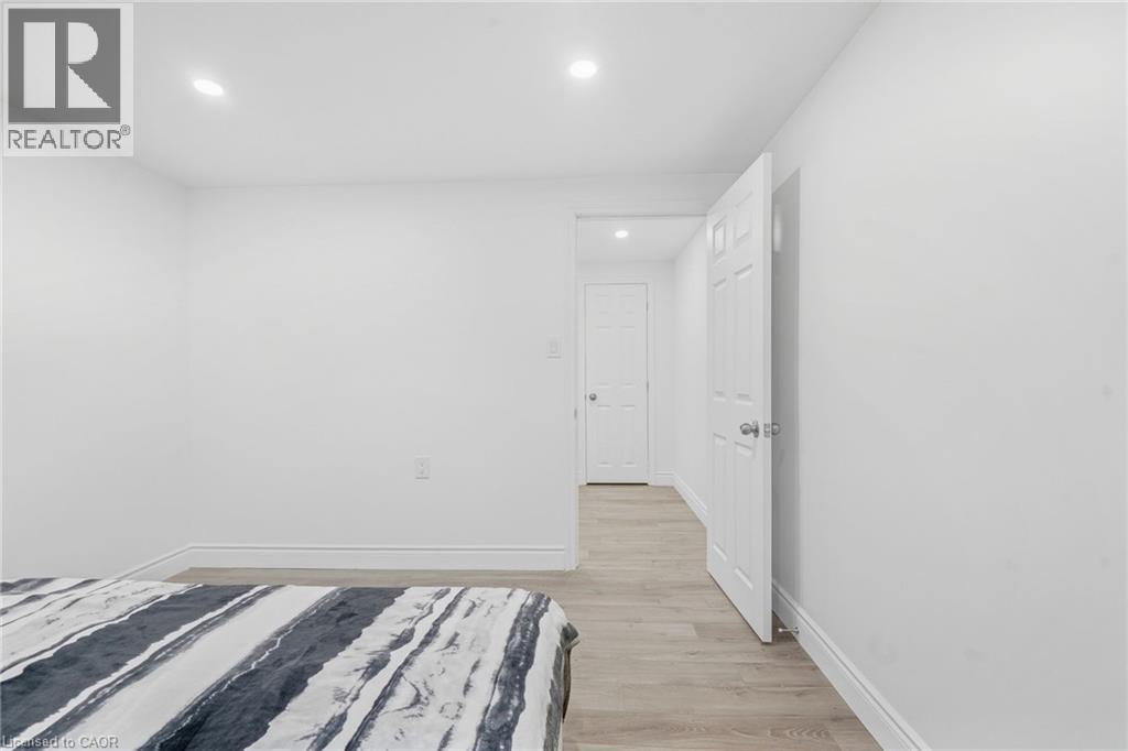Recessed lighting illuminates neutral white walls and wood-finish flooring - 49 Beverly Crescent, Welland, ON