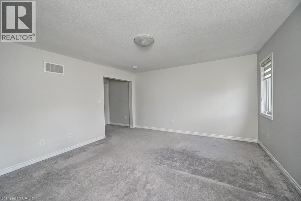 Neutral wall paint, ceiling-mounted light fixture, light gray carpet flooring, and white trim - 236 Ridge Road, Cambridge, ON