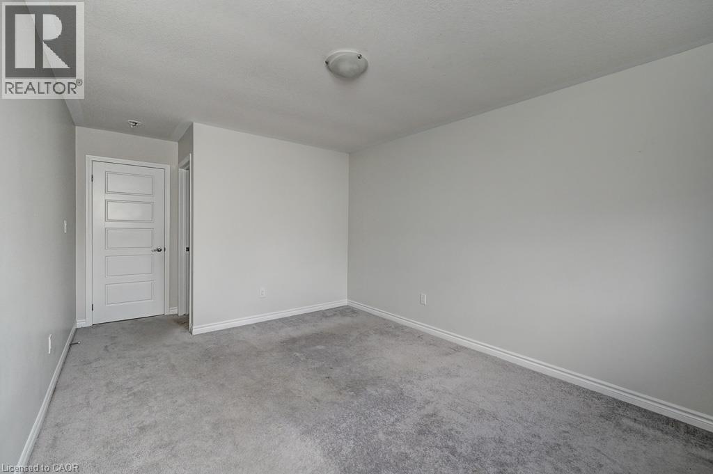 Neutral painted walls, grey carpet flooring, white trim, and a flush mount ceiling light fixture - 236 Ridge Road, Cambridge, ON
