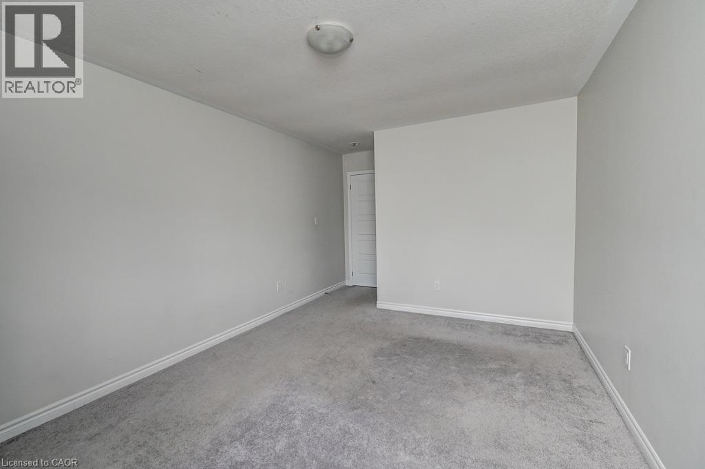 Light-toned wall finishes, neutral carpet, and white trim molding create a versatile interior - 236 Ridge Road, Cambridge, ON