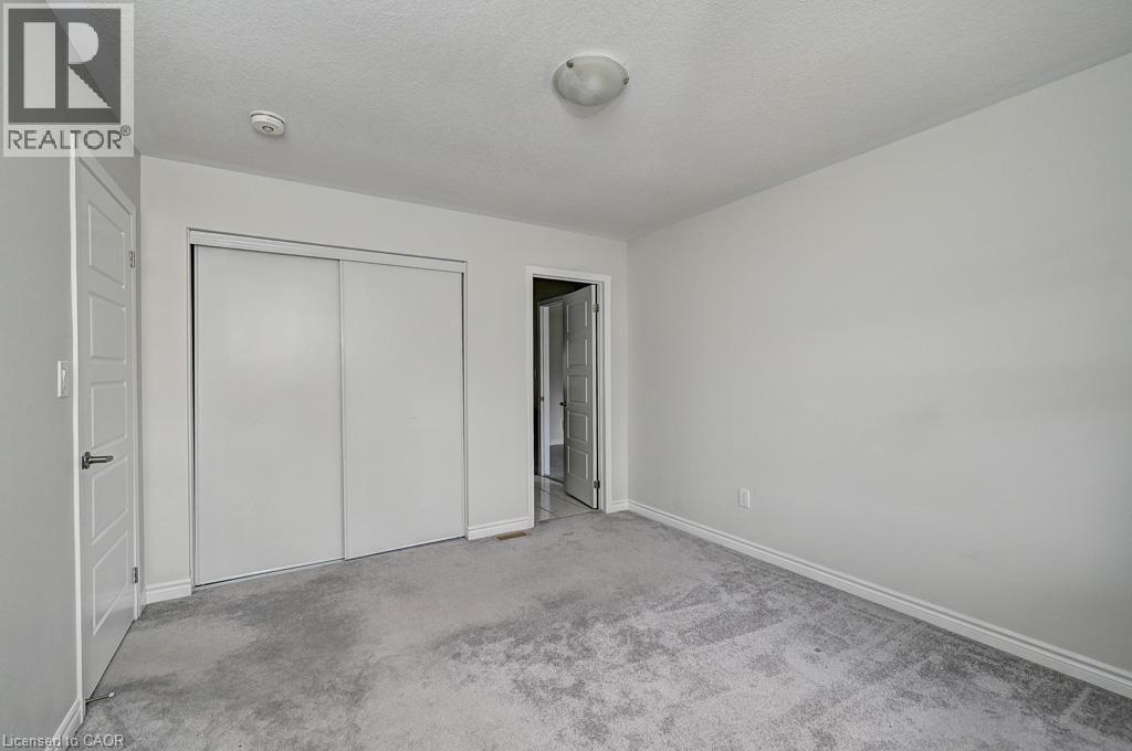 Light-colored carpeting, white walls, and a ceiling-mounted light fixture - 236 Ridge Road, Cambridge, ON
